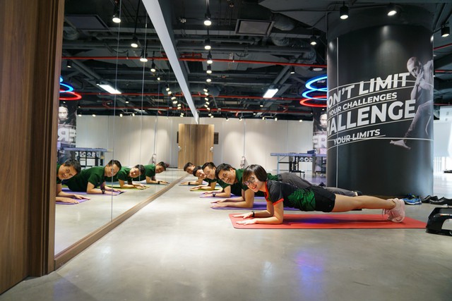 Chị Nguyễn Minh Trang (Khối Kiểm toán nội bộ) plank cùng các đồng nghiệp ngay tại phòng tập cơ quan.