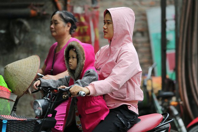 Hà Nội: Không khí lạnh tràn về, nhiệt độ giảm mạnh, người dân thích thú mặc áo ấm ra đường dưới trời mưa phùn - Ảnh 12.