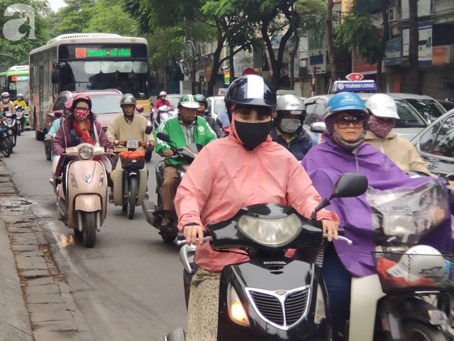 Hà Nội: Không khí lạnh tràn về, nhiệt độ giảm mạnh, người dân thích thú mặc áo ấm ra đường dưới trời mưa phùn - Ảnh 14.