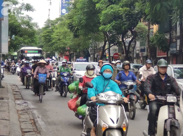 Hà Nội: Không khí lạnh tràn về, nhiệt độ giảm mạnh, người dân thích thú mặc áo ấm ra đường dưới trời mưa phùn - Ảnh 15.