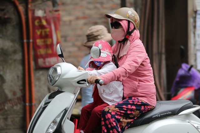 Hà Nội: Không khí lạnh tràn về, nhiệt độ giảm mạnh, người dân thích thú mặc áo ấm ra đường dưới trời mưa phùn - Ảnh 3.