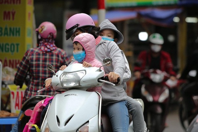 Hà Nội: Không khí lạnh tràn về, nhiệt độ giảm mạnh, người dân thích thú mặc áo ấm ra đường dưới trời mưa phùn - Ảnh 5.