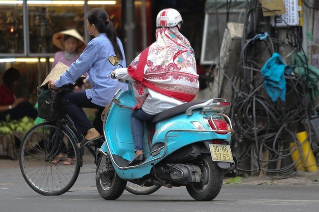 Hà Nội: Không khí lạnh tràn về, nhiệt độ giảm mạnh, người dân thích thú mặc áo ấm ra đường dưới trời mưa phùn - Ảnh 10.