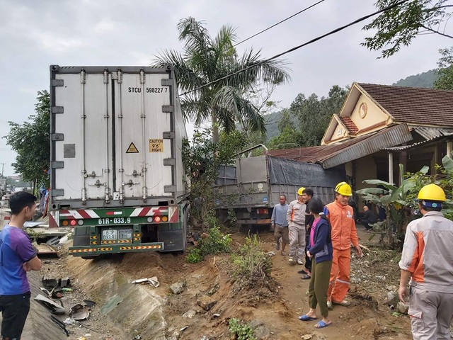 Hai xe tải đâm sập nhà dân, cả gia đình may mắn thoát chết - Ảnh 1.