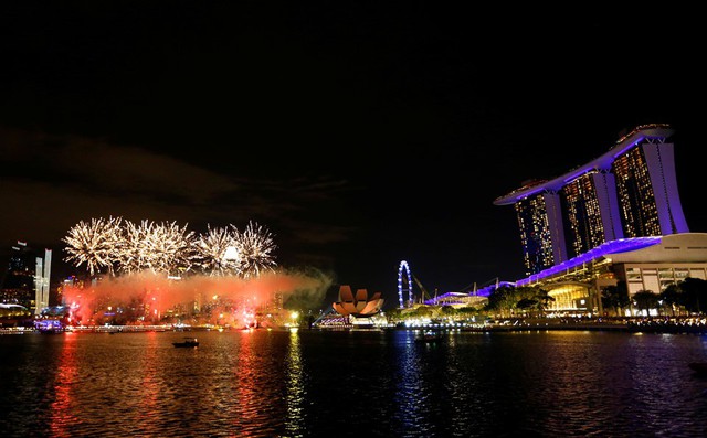 Buổi lễ hội pháo hoa tại Singapore bắt đầu sớm hơn những nước nằm trong cùng múi giờ. Buổi trình diễn này kéo dài đến gần một tiếng đồng hồ, theo Straits Times. Hoạt động bắn pháo hoa sớm trên vịnh Marina thật ra là một phần của chương trình đại nhạc hội và ánh sáng The Float. Ảnh: Reuters.