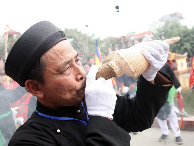 Bô lão trong làng thổi tù và từ vỏ ốc trong lúc điệu múa bồng cất lên.