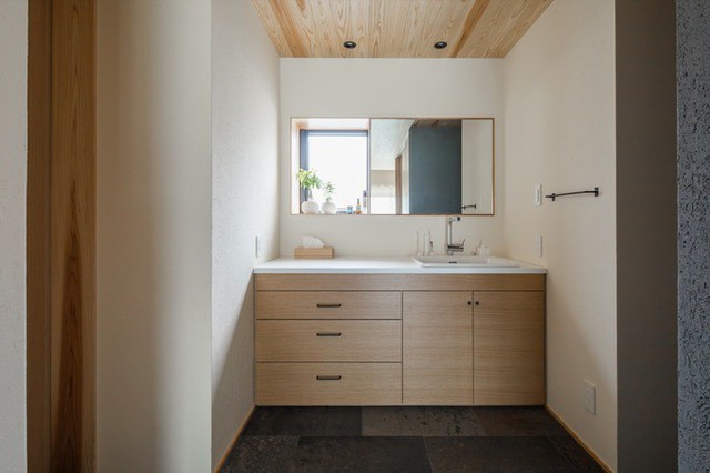 Nhà tắm đơn giản với tủ gỗ đựng đồ.