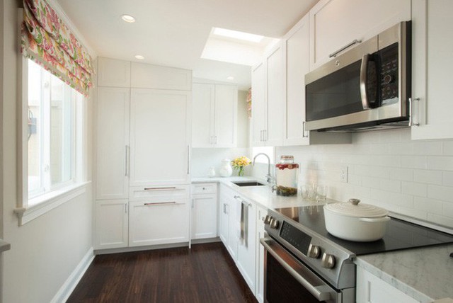 
3. Góc bếp đầy đủ tiện nghi là một trong những yếu tố thú vị để mọi người yêu thích vào nấu nướng dù căn phòng có nhỏ đến đâu. Thêm vào đó, hãy tạo sự thoải mái cho mọi người khi sử dụng gam màu tường trắng với màu tủ bếp trắng để tạo cảm giác rộng rãi cho căn phòng.
