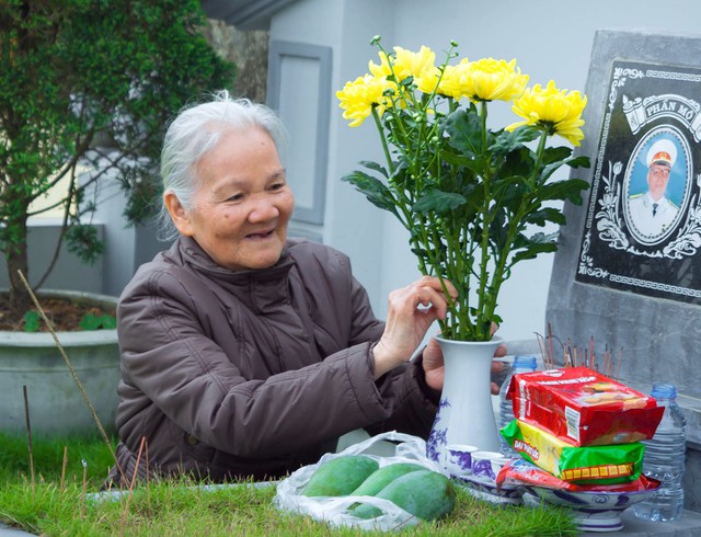 Cụ bà đang trò chuyện với cụ ông đã khuất trong ngày tảo mộ mời gia tiên cùng ông về ăn Tết với con cháu.