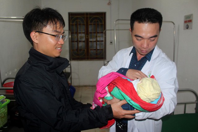 
Gia đình anh Hải đón con trai vừa chào đời trong đêm 30 Tết từ tay bác sĩ. Ảnh: Đ.Tùy
