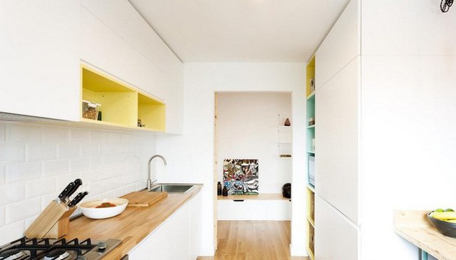 
Bên trong căn hộ là phòng bếp với tủ màu trắng âm tường có những hộc tủ màu vàng, xanh để tăng thêm nét đẹp trẻ trung, tràn đầy sức sống.
