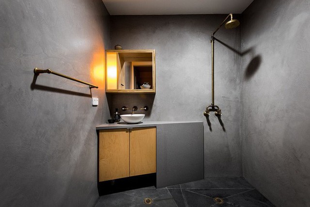 
Không gian phòng tắm trông có vẻ giống như một phòng xông hơi kiểu cũ với thiết kế tường tối màu bằng chất liệu gạch bê tông. Thêm vào đó, nội thất ở không gian này cũng được giản lược đi tối đa.
