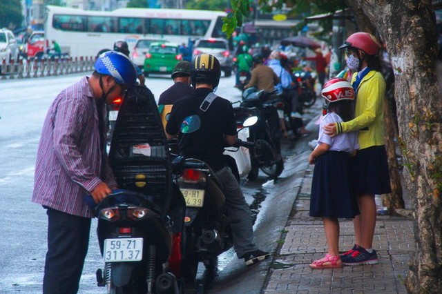 
Người dân vội vã tấp vào lề đường để mặc áo mưa, tìm nơi tránh trú.
