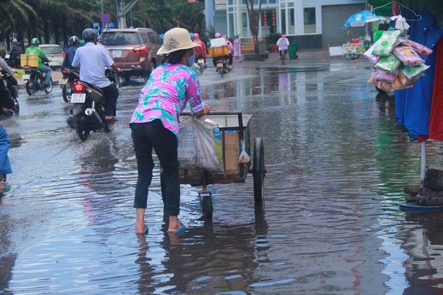 
Cơn mưa chỉ kéo dài khoảng 15 phút, tuy nhiên một số điểm thấp trũng đã ngập nước lanh láng, người dân phải lội bì bõm qua đường.
