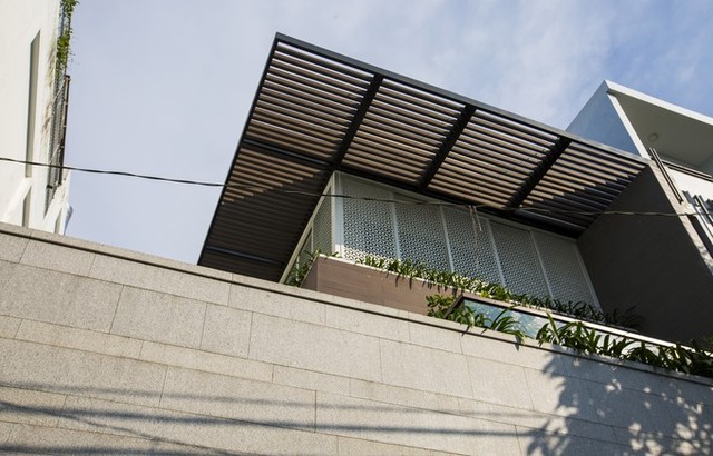 Ngôi nhà được nhóm kiến trúc sư thiết kế theo phong cách nhiệt đới hiện đại, với mái lam vươn ra ngoài 2 m, đủ để che nắng và chống mưa tạt bên ngoài, bảo vệ tường nhà quanh năm.