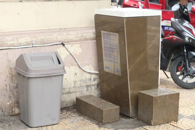 Ngoài ra, tại chợ Đồng Xuân, trụ nước sạch được đặt ngay cạnh thùng rác cũng gây mất vệ sinh cho nguồn nước bởi mùi hôi và ruồi nhặng bốc lên từ rác thải. Ảnh: Thu Phương