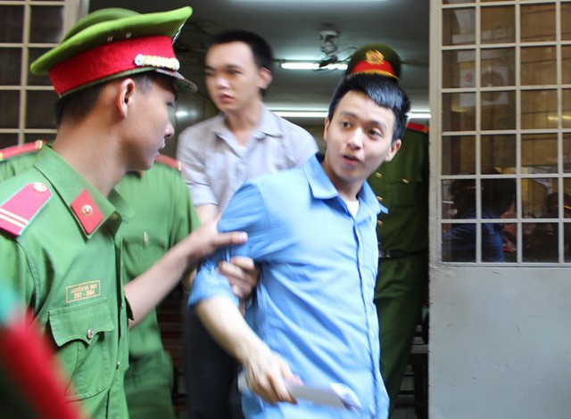 
Bị cáo Nhân (áo xanh), Quang (phía sau) tại tòa sáng 7/3. Ảnh: Hoài Thanh.
