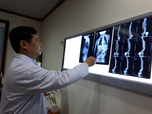 
PGS.TS Đinh Ngọc Sơn kiểm tra phim X-quang cho bệnh nhân. Ảnh: P.T

