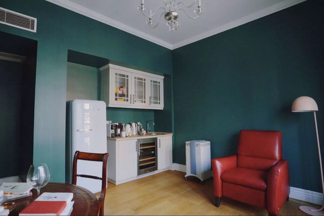
Để kết nối sắc màu với không gian chính, khu vực gần sofa được bố trí sơn tường xanh xuyên suốt cùng ghế đơn màu đỏ. Góc bếp nhỏ gọn đủ cho cuộc sống độc thân thêm tiện nghi.
