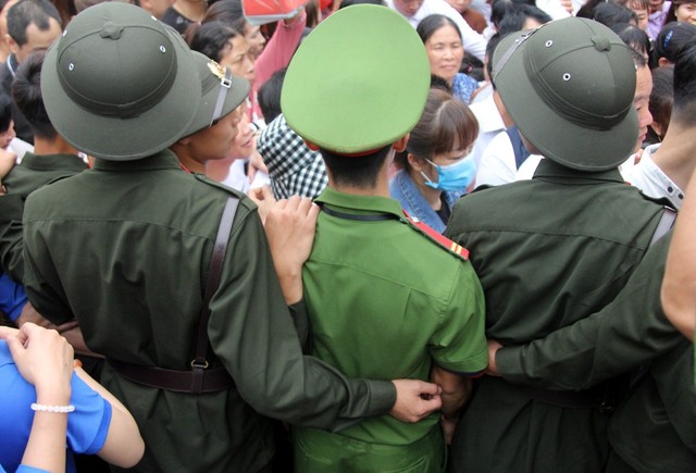 Lực lượng quân đội, công an, thanh niên tình nguyện kết thành hàng rào giúp người dân di chuyển trật tự.