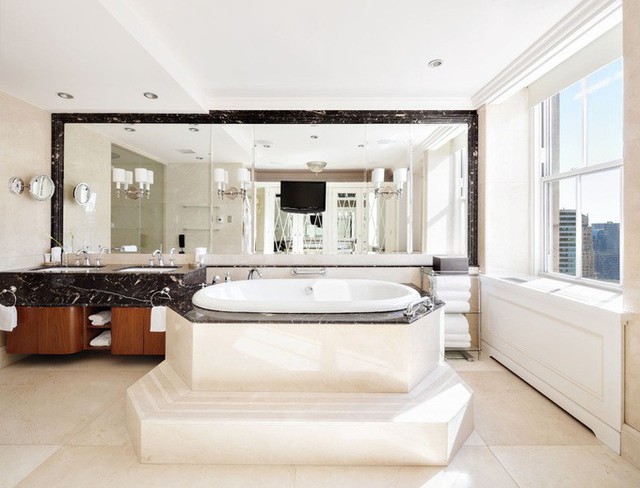 Phòng ngủ chính của căn hộ có phòng tắm riêng rộng lớn lát đá cẩm thạch, với bồn tắm lớn và vòi sen.