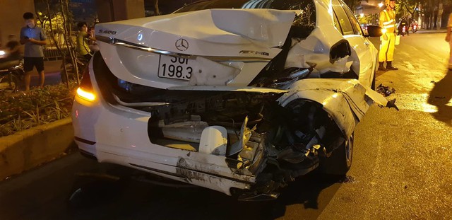 Ô tô Mercedes màu trắng mang BKS 30F-198.31 vỡ nát phần đuôi xe bên lái.