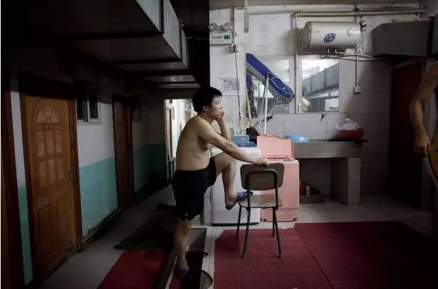 
Người đàn ông chờ đợi để sử dụng phòng tắm chung tại một khu nhà dưới tầng hầm ở ngoại ô phía tây Bắc Kinh.
