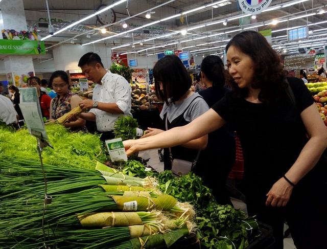 Ghi nhận tại quầy rau thơm thuộc siêu thị Big C Thăng Long sáng ngày 4/4 rất nhiều loại rau thơm, rau củ được bày bán gói bằng lá chuối thay vì màng bọc thực phẩm nilon như trước kia.