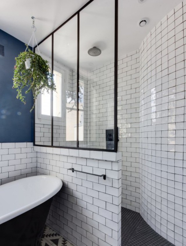 
Phòng tắm được chia hai khu vực chính là bồn tắm và góc tắm đứng phân tách bằng gạch và kính để ánh sáng dễ dàng tràn ngập khắp không gian.
