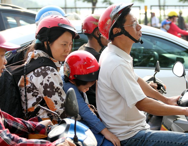 Trong khi đó, rất nhiều gia đình đã lựa chọn phương tiện xe máy để di chuyển từ các tỉnh lân cận trở về Hà Nội, do phải ngồi trên xe máy hàng giờ nên bé gái đã ngủ ngon lành trên lưng cha mẹ.