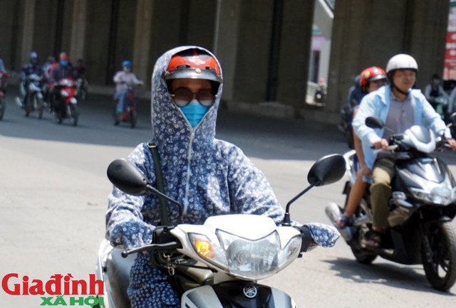 Một người phụ nữ chạy xe máy trong cái nắng nóng đỉnh điểm của mùa hè.