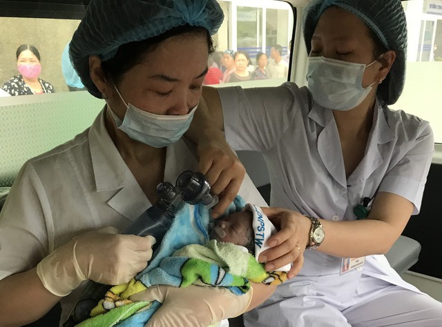 Em bé rất nhỏ nhưng khóc to lập tức được các bác sĩ cho thở oxy và đưa lên xe vận chuyển từ Bệnh viện K sang Bệnh viện Phụ sản Trung ương chăm sóc đặc biệt.