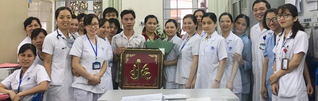 
Vợ chồng chị Hoàng Thị Hông chụp ảnh lưu niệm với tập thể y bác sĩ, điều dưỡng khoa Sơ sinh trước khi bồng bé Cường ra viện.
