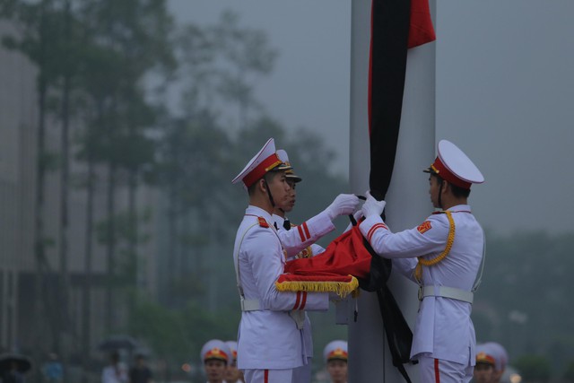 Lễ treo cờ được diễn ra trang nghiêm. Đội tiêu binh Bộ Tư lệnh Bảo vệ Lăng Chủ tịch Hồ Chí Minh mang theo lá cờ được gắn dải băng tang.