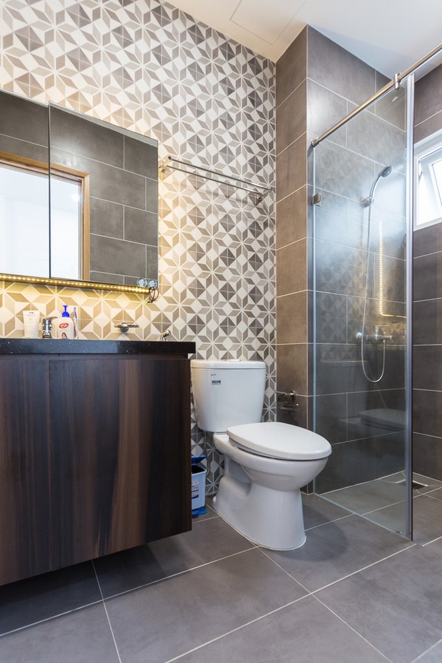 Nhà vệ sinh bên cạnh nội thất bằng gỗ, ở khu vực thường xuyên tiếp xúc với nước còn có gạch ốp tường và lát sàn màu nâu giả gỗ cũng tạo nên sự đồng nhất trong trang trí ở lầu 1.