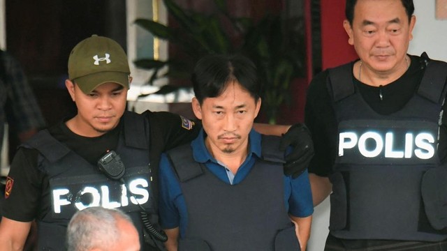 Ri Yong Chol bị cảnh sát áp giải ra sân bay để trục xuất. Ảnh: Kyodo.