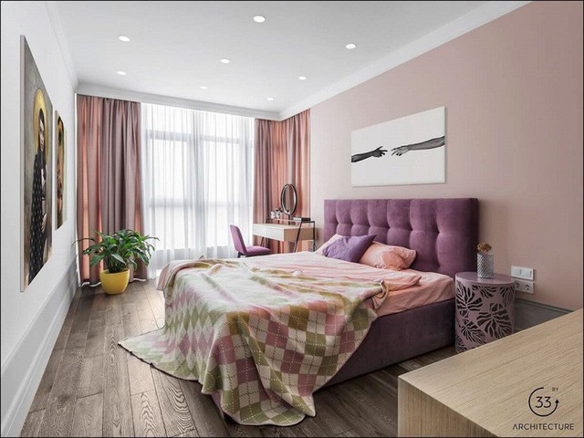 
Phòng ngủ chính là sự xuất hiện của bảng màu hồng và tím, thêm một chút điểm xuyết xanh lá cây đem tới cái nhìn sống động cho cả không gian. Một cây xanh nhỏ tiếp tục được đặt tại góc phòng.
