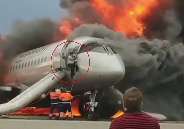Cơ phó Maxm Kuznetsov trèo khỏi cabin đầy khói sau khi máy bay bốc cháy ở sân bay Sheremetyevo hôm 5/5. Ảnh: Ren TV.