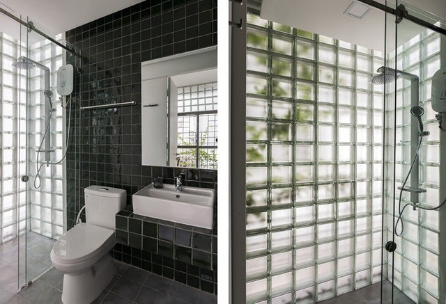Phòng tắm được hoàn thiện bằng sàn gạch bông màu xám, tường ốp gạch gốm thủ công màu xanh rêu đậm kết hợp với các vách gạch kính lấy ánh sáng tự nhiên bên ngoài.