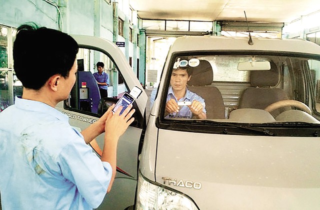 
Dán thẻ E-tag trên kính ô tô tại một trung tâm đăng kiểm xe cơ giới. Ảnh: PV
