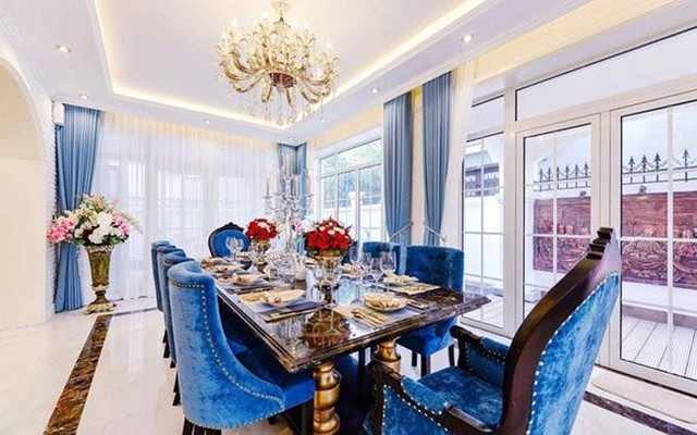 Phòng khách liền với khu để bàn ăn, hai bộ bàn ghế đều có màu xanh dương cùng tông. Bàn ăn cũng được chủ nhân căn hộ bài trí cầu kỳ.