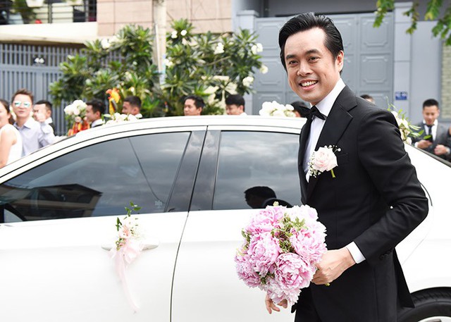 Dương Khắc Linh bảnh bao trong lễ phục chú rể, cầm hoa cưới tiến vào nhà cô dâu Sara Lưu ở quận 8 TP HCM.