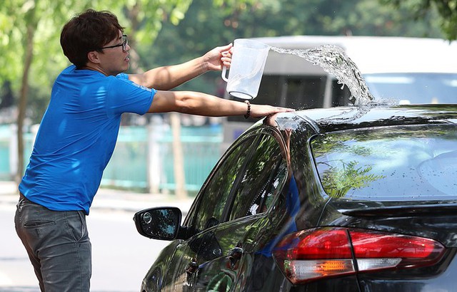 Trên phố Nguyễn Đình Thi, người tài xế sử dụng nước làm mát cho ôtô. Dự báo, nhiệt độ cao nhất hôm nay ở Hà Nội khoảng 40 độ C.