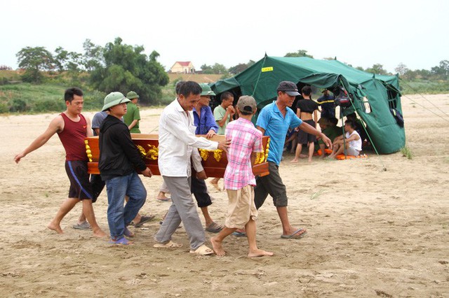 Người thân đưa quan tài ra bờ sông để làm thủ tục đón nhận thi thể về mai táng.