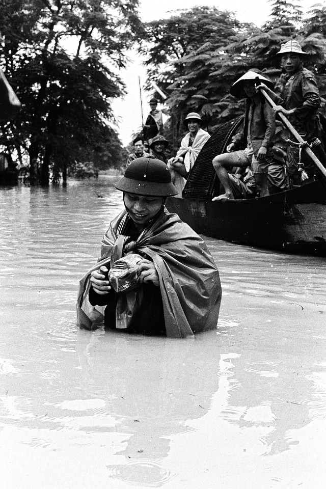 
Nhà báo Trần Tuấn tác nghiệp trong trận bão lụt lịch sử tại Huế, cuối năm 1975 (ảnh nhân vật cung cấp).

