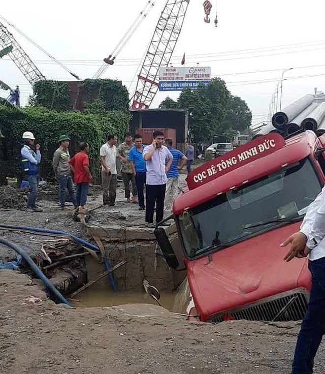 
Chiếc xe container sụt lún xuống hố sâu ở gần chân cầu vượt Phú Thụy.
