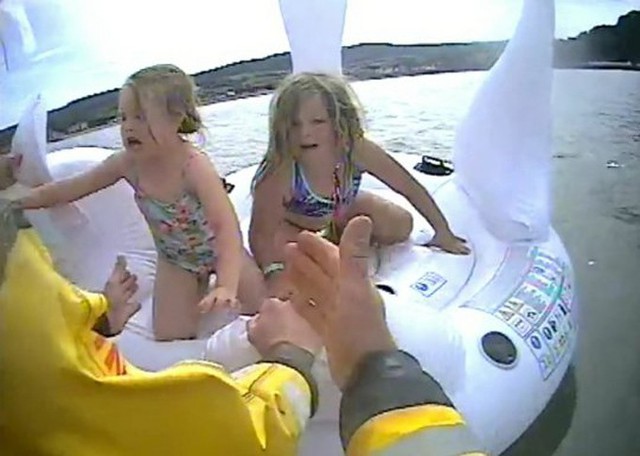 Hai bé gái mếu máo khi được các nhân viên cứu hộ bế lên thuyền cứu sinh. Ảnh: RNLI.