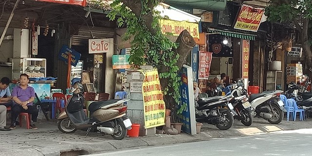 Nhiều chủ quán ăn bất chấp nguy hiểm đặt cả những tấm quảng cáo, biển hiệu lên trên bốt điện. Ảnh chụp trên đường Lê Duẩn.