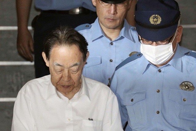 Cựu thứ trưởng nông nghiệp Nhật Bản Hideaki Kumazawa (áo trắng) bị cảnh sát bắt giữ với cáo buộc giết con trai là Eiichiro Kumazawa. Ảnh: Reuters.
