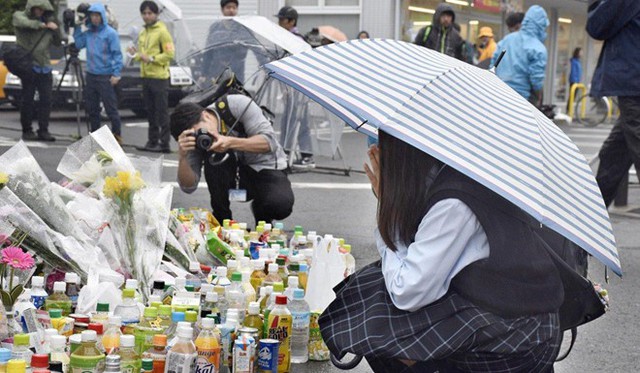 Người dân khu vực Kawasaki, ngoại ô thủ đô Tokyo, đặt hoa và những chai nước ngọt tại nơi xảy ra vụ đâm dao kinh hoàng ngày 28/5 để tưởng niệm hai nạn nhân đã mất. Ảnh: Kyodo.